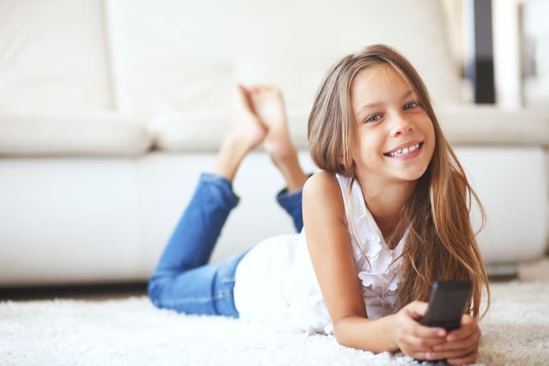 little girl lying on white carpet