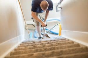 Carpet cleaning technician job cleaning carpeted staircase