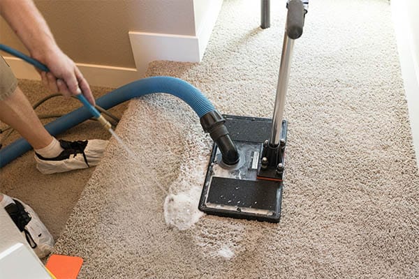 Flood extractor removing water from carpet