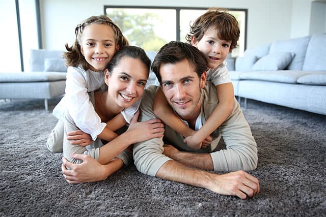 Family lying together on grey carpet