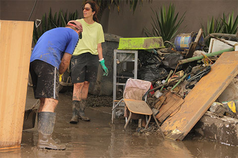 wearing rubber boots and gloves water restoration PPE